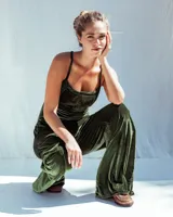 Enterito de terciopelo color verde militar, estilo cargo con múltiples bolsillos en las piernas y el pecho, tiras ajustables en la espalda y piernas amplias de corte recto.