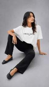 Remera blanca oversize de calce relajado, con cuello redondo, manga corta y bordado con la frase "COOL AND TRENDY" en el frente.
