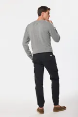 Pantalón cargo azul marino con bolsillos laterales con solapa y cinturón de cuero marrón.