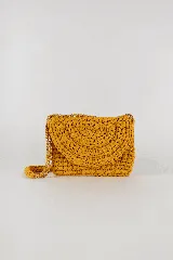 Cartera bandolera tejida a crochet color mostaza, con correa de cadena dorada y forro interior con cierre de botón imán.