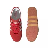 Zapatillas Adidas Gazelle Lo Pro de gamuza color rojo con las tres tiras laterales en blanco y suela de goma color caramelo.