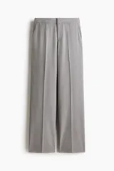 Pantalón sastrero gris de tiro alto, con cierre y corchete ocultos, piernas rectas con raya marcada al frente y en la espalda, y bolsillos laterales al bies.