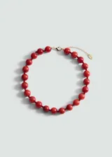 Gargantilla de piedras rojas redondas, engarzadas con hilo rojo y cierre de mosquetón dorado con cadena de alargue.
