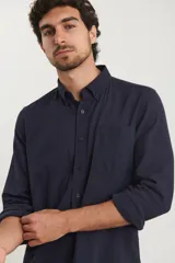 Camisa de manga larga con cuello abotonado y bolsillo frontal, confeccionada en una mezcla de algodón y lino.