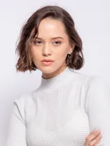 Polera de tejido de punto con diseño de textura tramada y pequeños puntos calados, de corte ajustado al cuerpo y cuello alto.