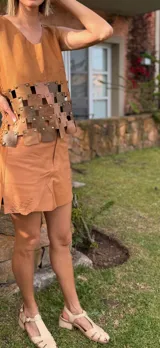 Top color ocre con frente de cuero y espalda tejida de punto. Presenta apliques de piezas de cuero unidas con tachas.