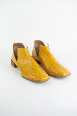 Botin de cuero con acabado grabado efecto avestruz, diseño con aberturas laterales y taco bajo cuadrado.