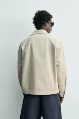Sobrecamisa de corte regular fit en color beige, confeccionada en popelín de algodón. Cuenta con cuello solapa, manga larga con puño abotonado, bolsillos ocultos en las costuras de la cadera y cierre frontal con botonadura oculta.