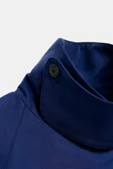 Cazadora de cuello solapa y manga larga, color azul, con diseño cruzado y cierre frontal con botones.