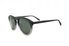 Lentes de sol de montura gruesa estilo wayfarer, con frente en degradado de negro a gris claro y lentes verdes oscuros. Las patillas son negras y llevan la inscripción "PROTOTYPE" en blanco.