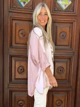 Blusa de corte holgado y diseño asimétrico, confeccionada en una combinación de satén y tejido de punto con viscosa. Presenta mangas largas y un acabado suave con caída fluida.