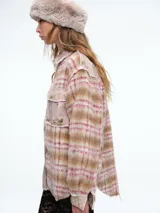Camisa de corte oversize confeccionada en tejido de textura suave con estampado de cuadros y detalles de patchwork floral en los bolsillos delanteros, cuello y tapeta de botones. Presenta bordes deshilachados, cierre frontal con botones metálicos y dos bolsillos con solapa en el pecho.