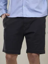 Bermuda azul marino de corte casual, confeccionada en mezcla de algodón, poliéster y spandex, con acabado teñido garment dye y bolsillos laterales.