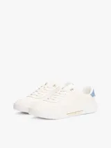 Zapatillas de tenis Tommy Hilfiger confeccionadas en piel napa blanca. Poseen un diseño de corte bajo con cierre de cordones, panel metalizado en el talón y un ribete lateral con el logo de la marca grabado. Incluyen forro de poliéster y suela de goma.