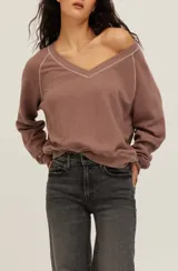 Sudadera Cambridge de felpa color marrón con escote en V amplio y costuras decorativas en contraste de color crudo. Tiene mangas largas de corte raglán, diseño holgado y puños y bajo de canalé.