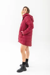 Campera puffer acolchada de color bordó, con cierre frontal completo, capucha desmontable y bolsillos laterales con cierre.
