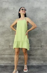 Vestido corto verde lima con textura plumeti, corte suelto, breteles finos y volado en el ruedo.