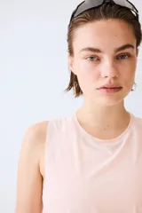Musculosa deportiva rosada de corte estándar, confeccionada en tejido funcional DryMove que ayuda a absorber el sudor, con cuello redondo y aberturas laterales en el bajo.