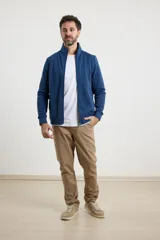 Cardigan de tejido de punto color verde militar, con cierre frontal de metal y cuello redondo. Presenta detalle de tejido plano en la cartera del cierre y en los bolsillos laterales.