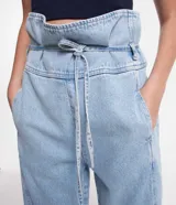 Pantalón clochard de jeans celeste, con cintura alta ajustable con lazo, bolsillos delanteros y traseros.