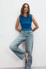 Jeans de denim de tiro medio y corte relaxed con diseño de cinco bolsillos, trabillas en la cintura y cierre frontal con cremallera y botón metálico.