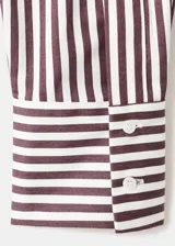 Camisa de corte recto confeccionada en mezcla de algodón y poliéster, con estampado de rayas. Cuenta con cuello camisero, manga larga con puños abotonados, bolsillo de parche en el pecho y cierre frontal con botones.