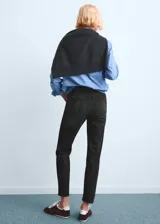 Jeans mom-fit de tiro alto y diseño crop, color negro, con cinco bolsillos, trabillas para cinturón y cierre frontal con cremallera y botón.
