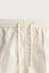 Short de baño de color azul marino, confeccionado en tejido técnico, con cintura elástica ajustable mediante cordón, bolsillos laterales y detalle de bolsillo trasero.