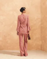 Blusa estampada color salmón con diseño geométrico, escote en V, mangas largas acampanadas y nudo lateral.