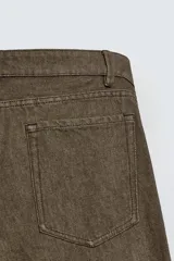 Pantalón de corte recto confeccionado en denim de algodón rígido con efecto lavado. Presenta tiro medio, cierre frontal con cremallera y botón, y diseño clásico de cinco bolsillos.