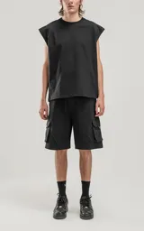 Bermuda negra de algodón rústico, corte oversize, con cintura elástica y bolsillos cargo con cierre en los laterales.