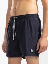 Short de baño azul marino con bordado de enredadera en la pierna izquierda. Tiene cintura elástica con cordón regulable, bolsillos laterales y trasero con cierre, y suspensor de malla fina hipoalergénico.