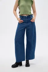 Pantalon de jean azul de corte amplio y tiro bajo, con costuras laterales curvas que le dan una silueta redondeada.