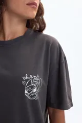 Remera oversize de manga corta color gris oscuro, con estampado trasero de Stitch y la frase "Best Friend" en la parte superior. Incluye descripciones de Stitch como "Fluffy... and cute!", "Energetic always ready for fun!", "Talented excellent guitar player", "Ohana nobody gets left behind", "Super intelligent thinks faster than a supercomputer!" y "Alien from outer space!".