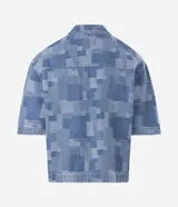 Camisa de jean de algodón con textura jacquard y diseño geométrico, de corte boxy, cuello con solapa, manga corta y cierre frontal con cremallera.