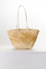Bolso tipo shopper de paja color beige con diseño geométrico en marrón. Asas de cuero sintético color crema.