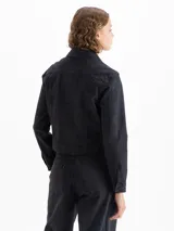 Campera de denim color negro, de silueta clásica y fit estándar, con leve elasticidad. Tiene cuello camisero, botones frontales y bolsillos con solapa en el pecho.