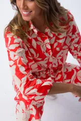 Camisa roja con estampado de hojas color crema, de corte suelto y manga larga.