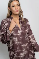 Vestido corto color beige con estampado de paisajes en marrón, cuello mao y mangas largas con puños abotonados.