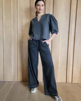 Pantalón de denim azul, de corte recto y tiro alto, con cintura elástica y cordón ajustable. Tiene bolsillos laterales.