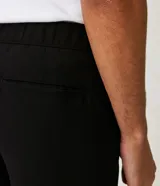 Pantalón masculino de corte slim cropped, confeccionado en viscosa con cintura elástica, bolsillos laterales y traseros, y pliegues delanteros.