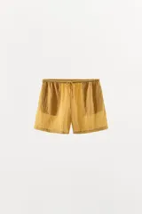 Bermuda de tiro medio confeccionada en mezcla de lyocell, con diseño a rayas en tonos amarillos y blancos. Cuenta con cintura elástica ajustable con cordón y bolsillos laterales.