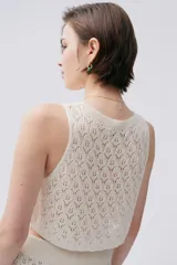 Top tejido color crudo con puntos calados, de calce corto y relajado.