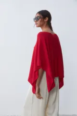 Poncho tejido de punto color rojo con cuello bote y corte asimétrico.