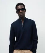 Suéter de punto color marrón, con cuello alto y cierre frontal parcial tipo half-zip, de manga larga y diseño regular.