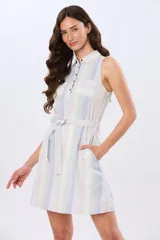 Vestido corto sin mangas de lino con diseño de rayas verticales en tonos claros, cuello camisero, botones frontales y lazo ajustable en la cintura.