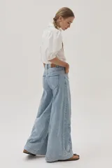 Jean de calce recto y tiro medio-alto, color celeste claro, con bordado a lo largo de la pierna.