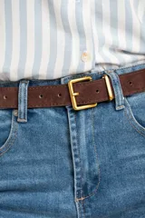 Cinto marrón de gamuza con hebilla cuadrada dorada.