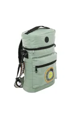 Mochila cilíndrica negra, tipo matera, con múltiples bolsillos frontales con cierre. Presenta un logo circular grande en verde neón con una 'D' estilizada y un globo terráqueo. Las correas son negras con texto en verde neón.