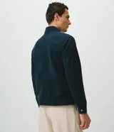 Campera Harrington de gamuza sintética color verde oscuro, de manga larga, con cuello camisero y cierre frontal completo.